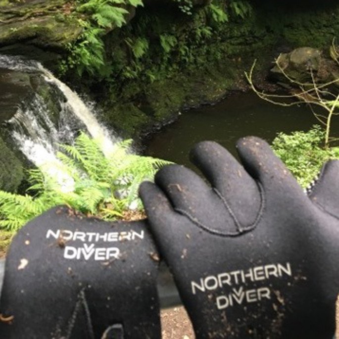 Chris Murphy post cliff jump, drying his Northern Diver gloves