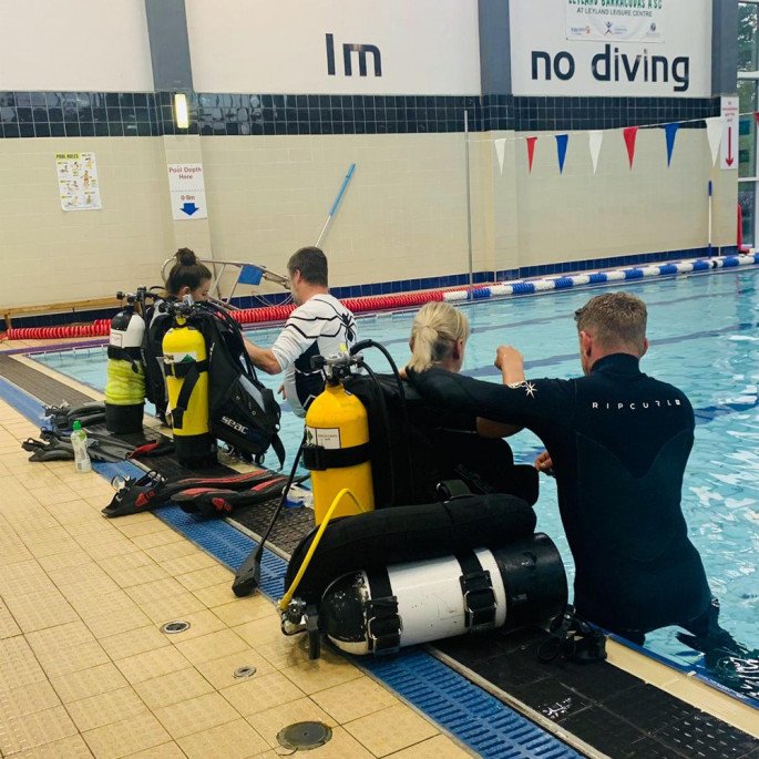 Maddie and Kristine from Northern Diver at a Chorley BSAC Try-Dive session - getting put in to their BCDs